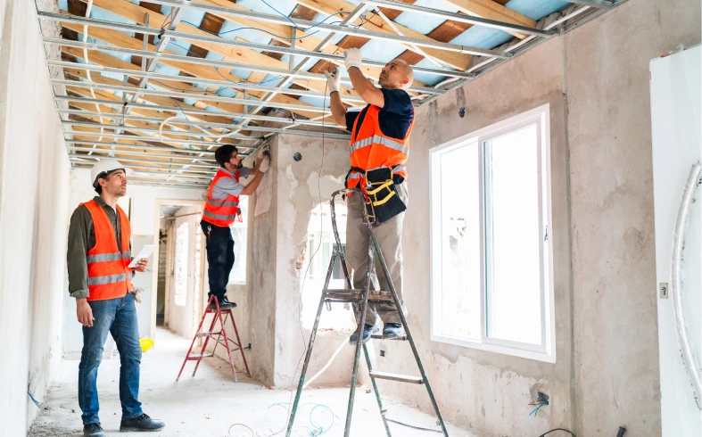 Construction workers installing ceiling framework