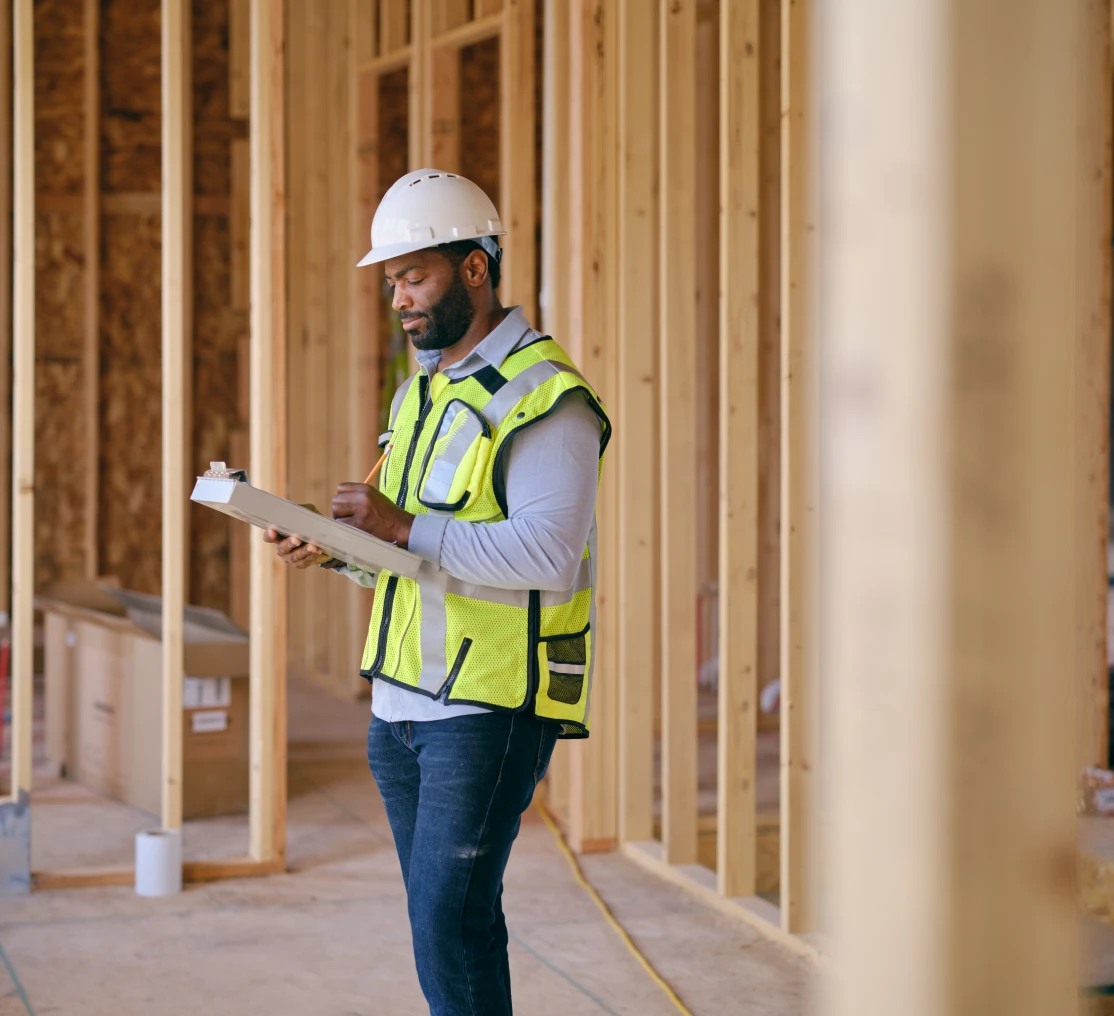 Worker in hard hat and vest indoors